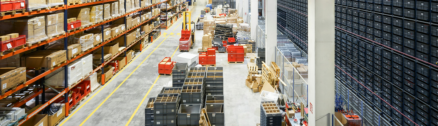 An image of a large warehouse with forklifts and boxes in it