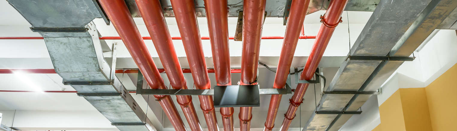 Red fire protection pipes installed along the ceiling of a commercial building