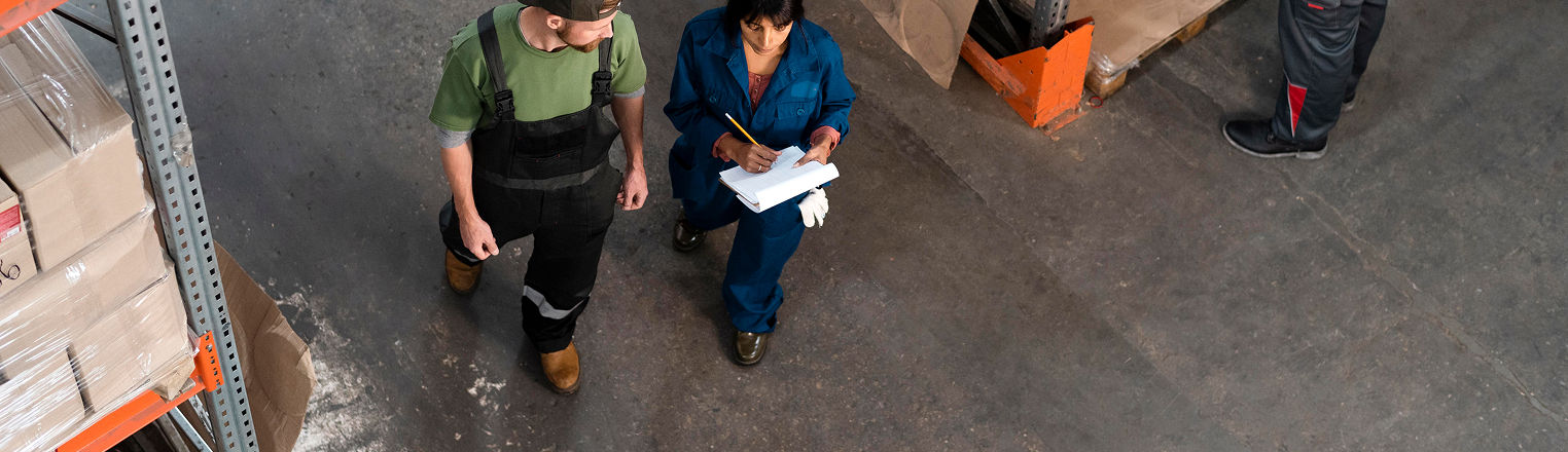 2 workers going over checklist in a warehouse